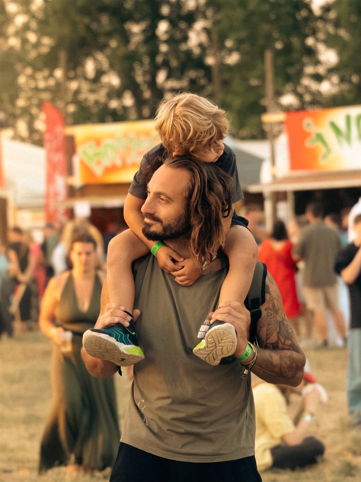 Kind op de schouders van zijn vader tussen de foodtrucks